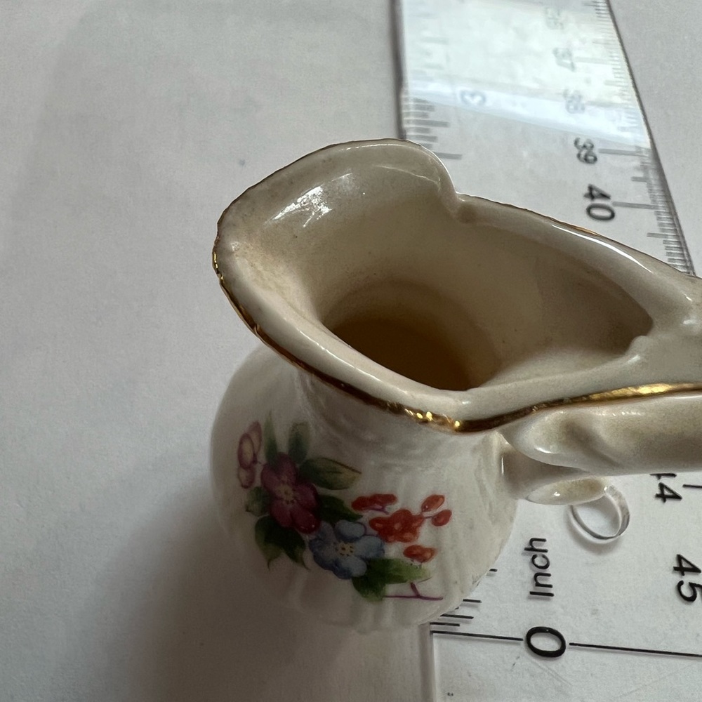 Miniature vase with flower bouquet on front and small flower on reverse.
